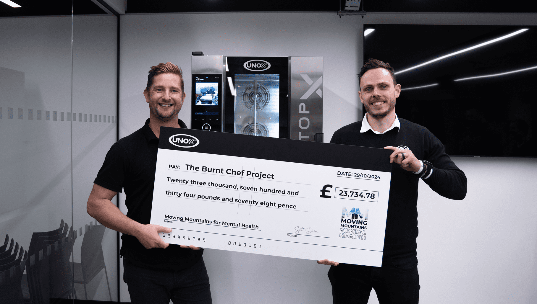 the burnt chef project founder receiving donation cheque from moving mountains